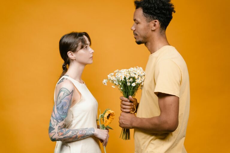 woman standing in front of apologizing man with flowers
