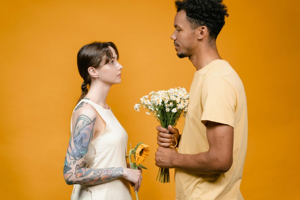 woman standing in front of apologizing man with flowers