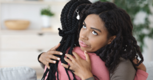 irritated woman hugging another woman