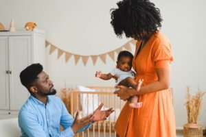 man reaching for baby from mother showing coparenting